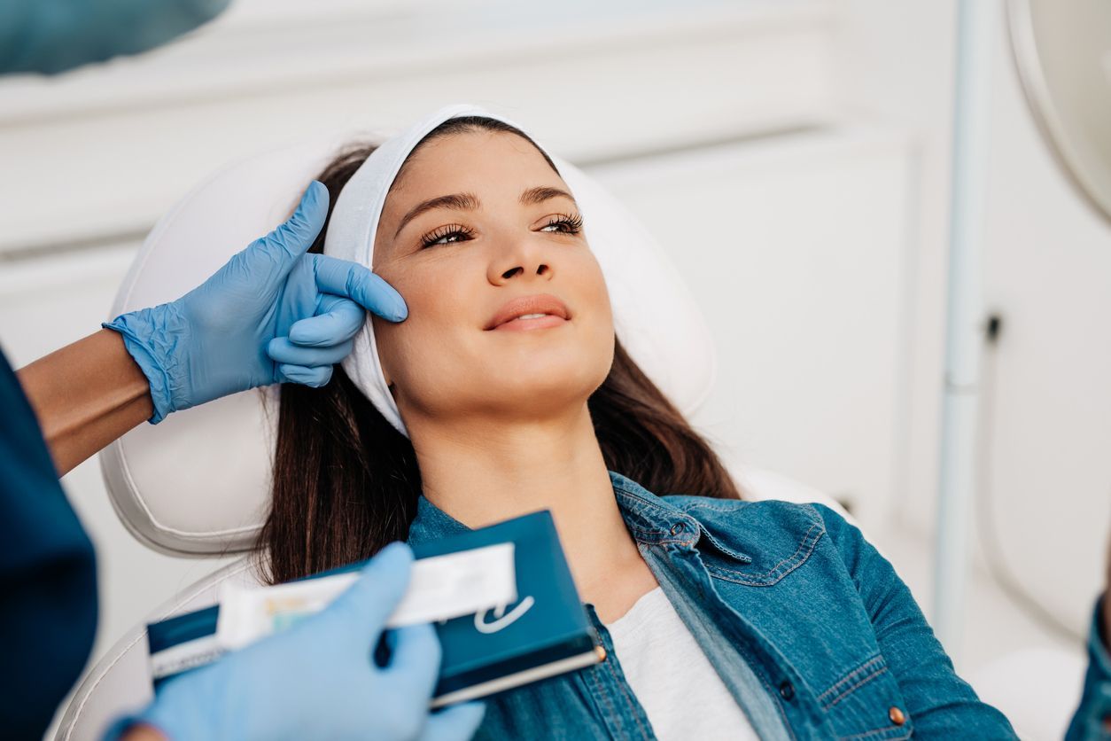 Person receiving a facial treatment with gloved hands in a spa setting