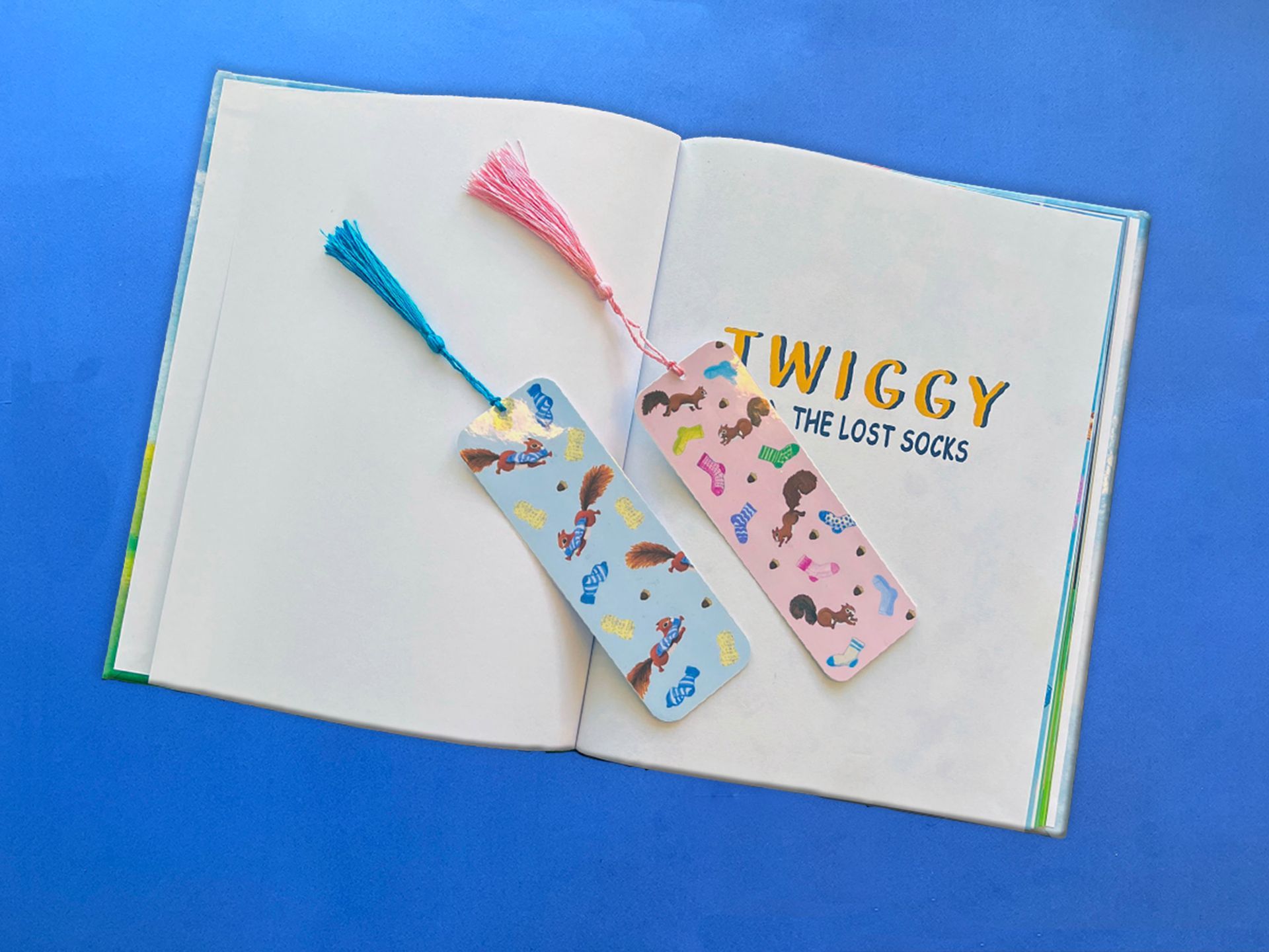 Open book with two colorful bookmarks; blue background.