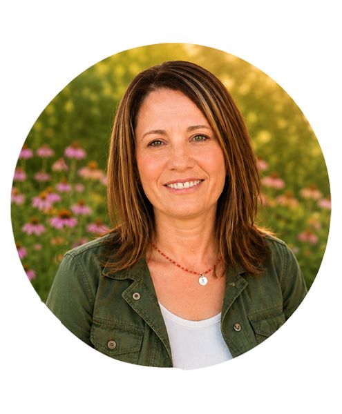 Portrait of children’s author and illustrator Renée DeVincent smiling outdoors in a flower garden.
