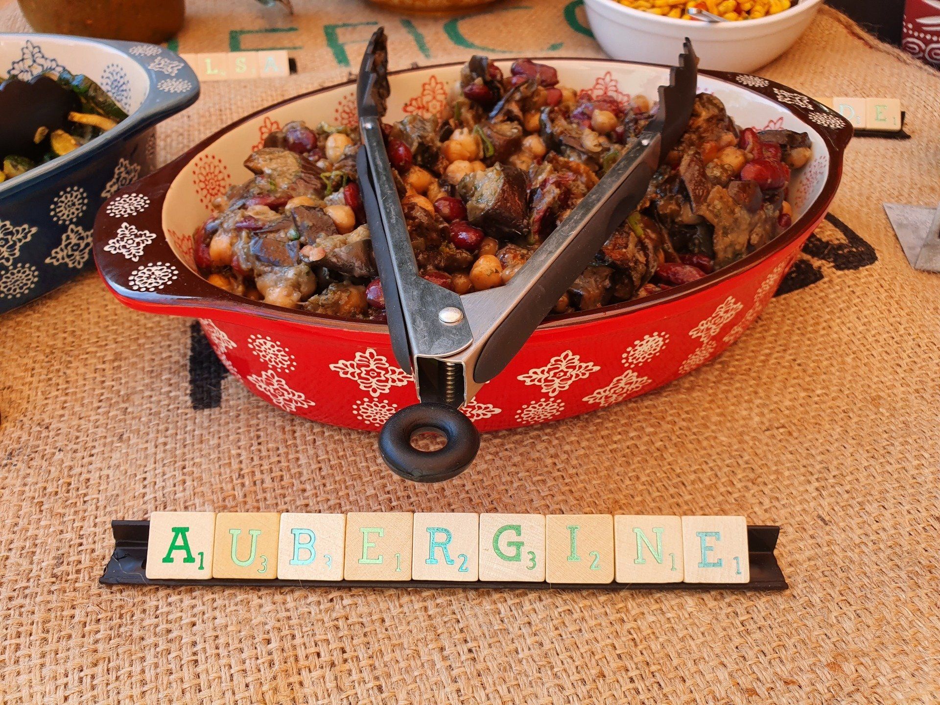 Ovale rode schaal met gegrilde aubergine met scrabble-letters 