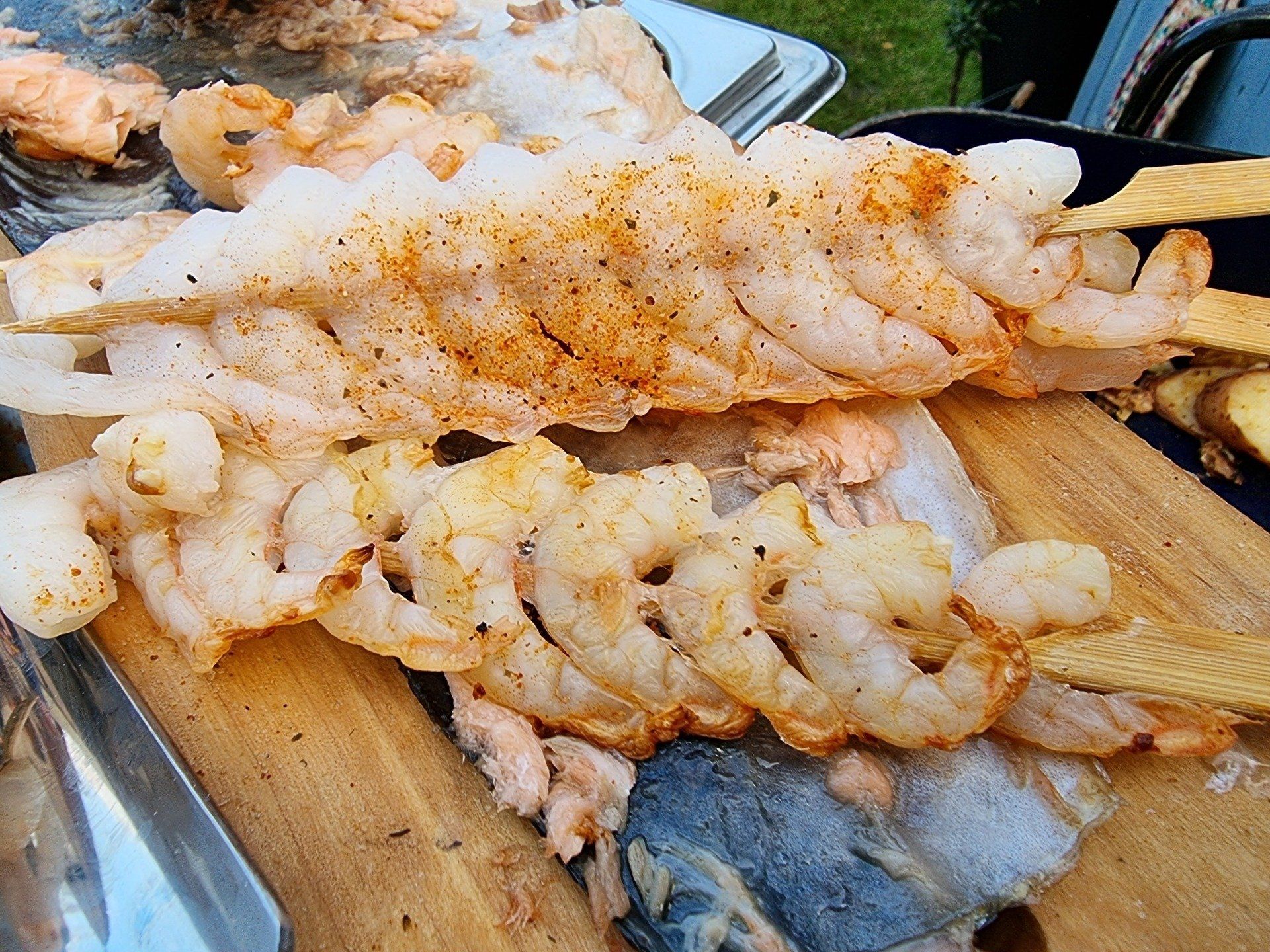 Gegrilde gamba's aan houten spiesjes, gekruid met specerijen.