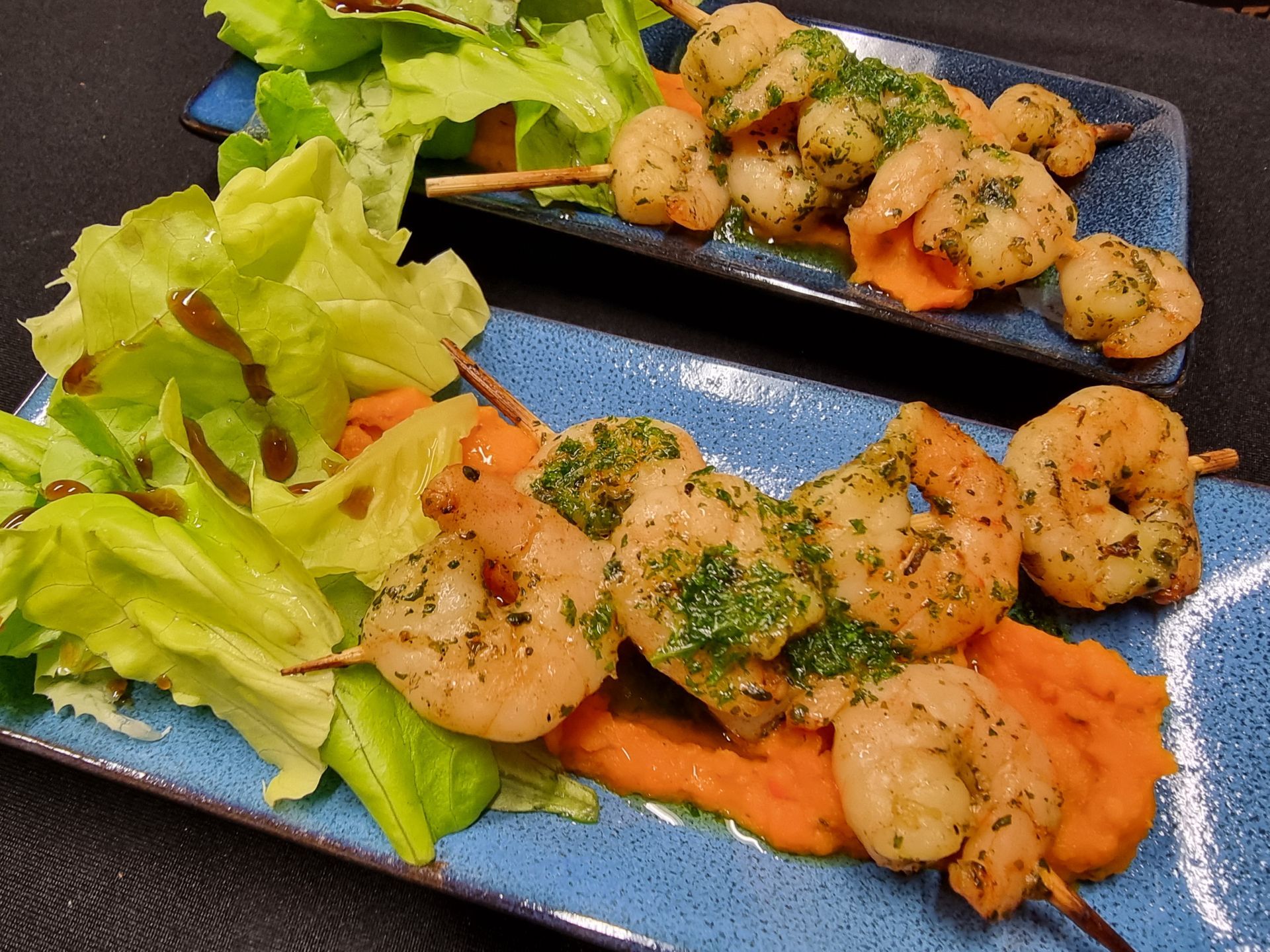Gegrilde garnalenspiesjes met zoete aardappelpuree en salade.