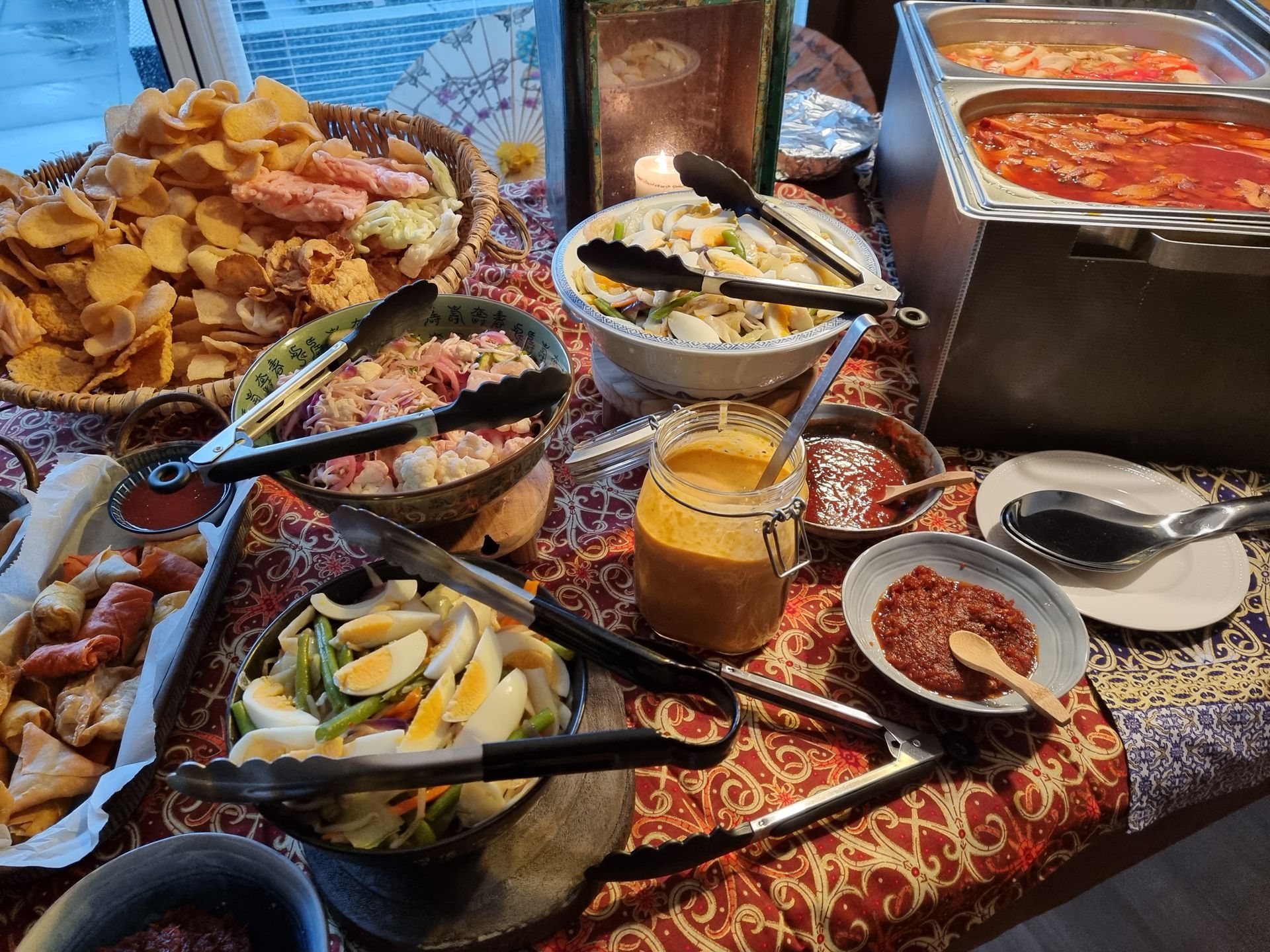 Een Aziatisch buffet met diverse gerechten: salades, sauzen en hapjes op een mooi gedecoreerde tafel.