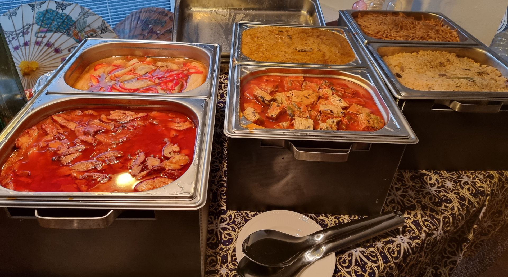 Buffet met diverse chafing dishes gevuld met verschillende Aziatische gerechten, waaronder foe yong hai, bami en rijst.