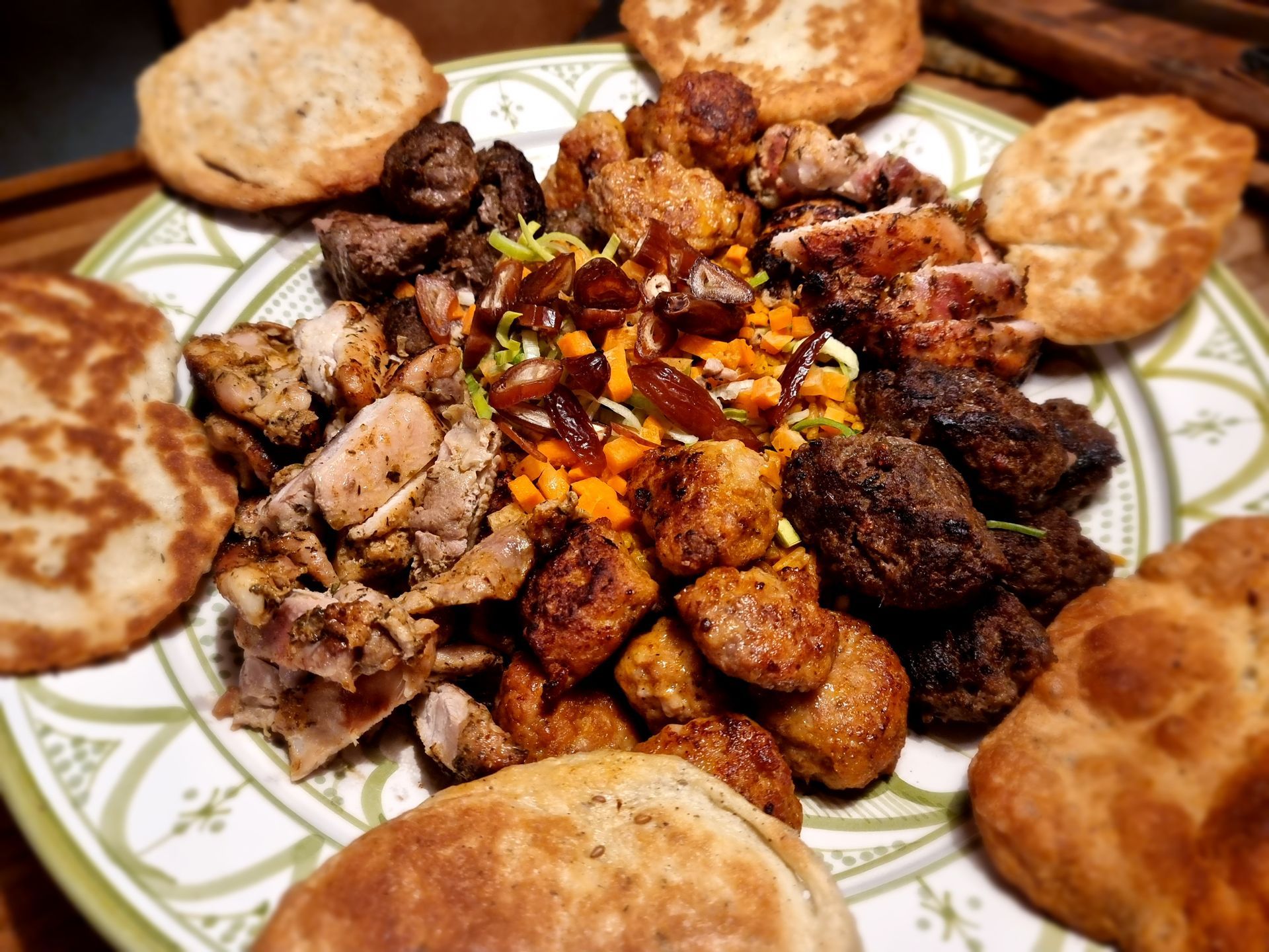 Diverse soorten vlees en pilaf met platbrood op een mooi gedecoreerd bord.
