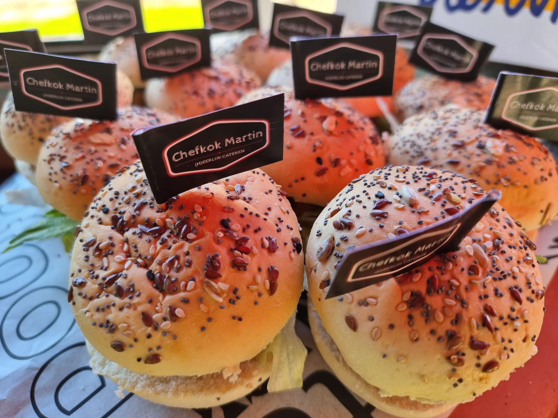 Mini-burgers met sesamzaadbroodjes, elk voorzien van een 
