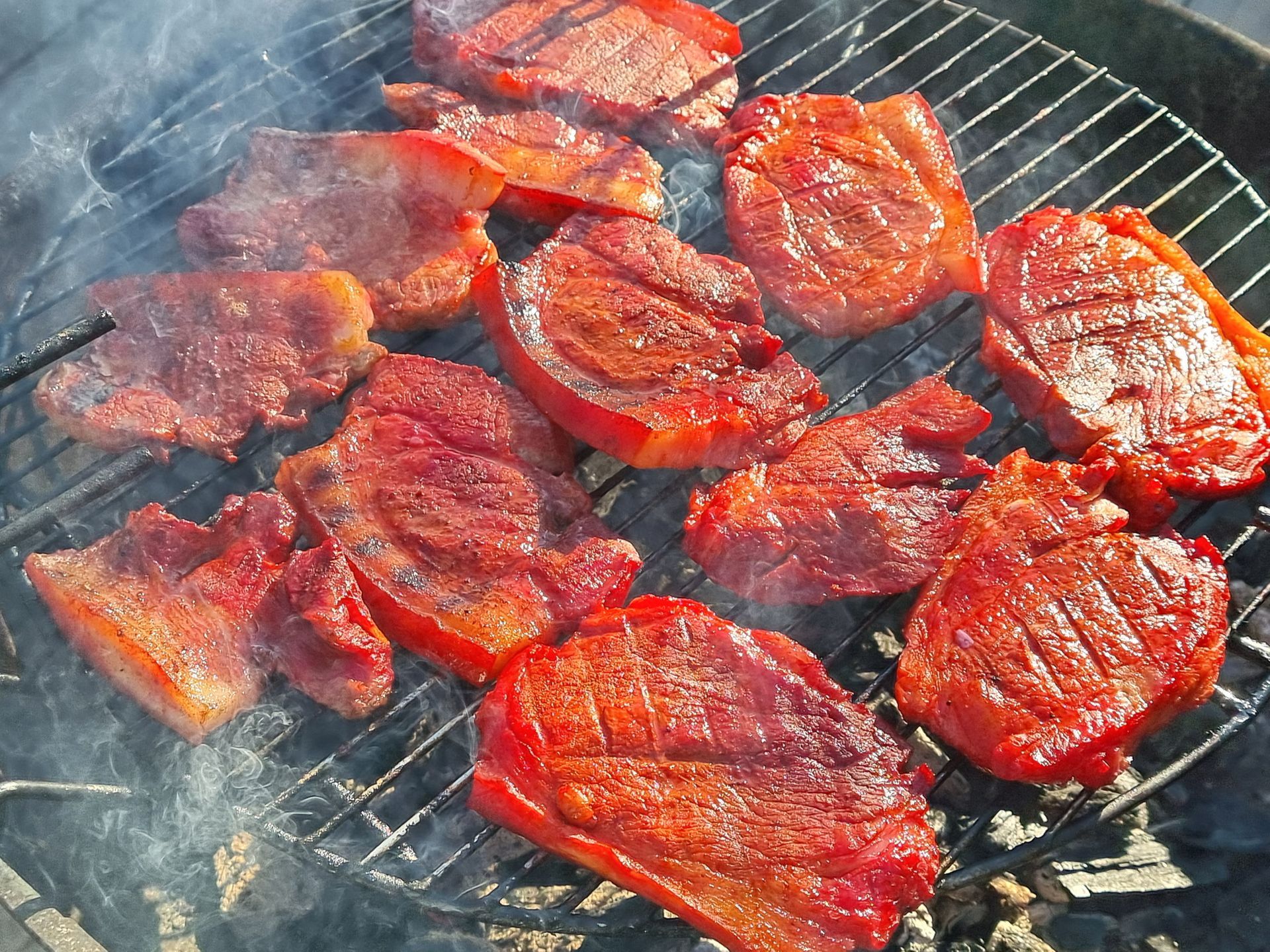 Gegrilde procureur op een rond, metalen rooster, met opstijgende rook.