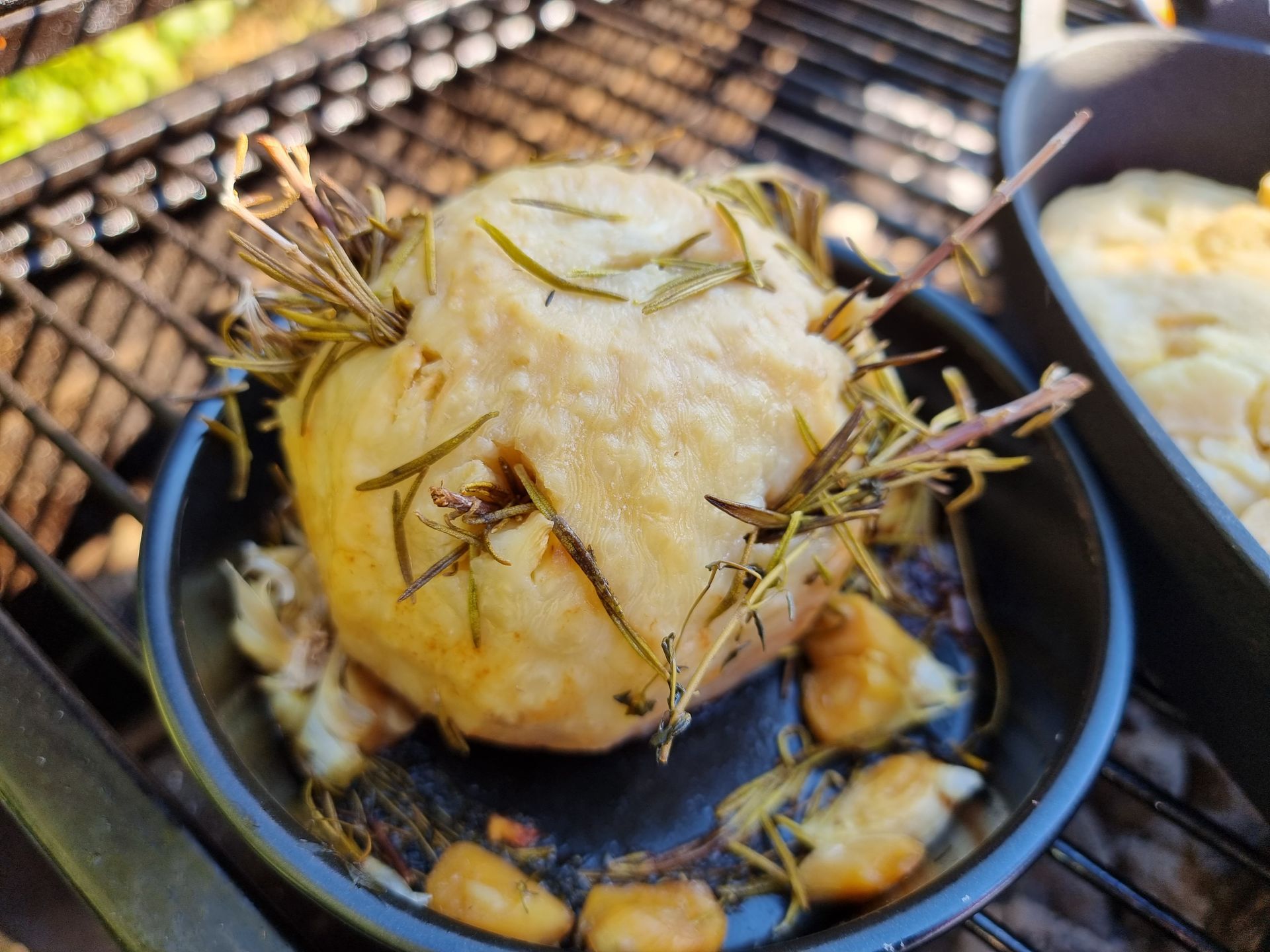 Geroosterde venkelknol met rozemarijn in een zwarte pan op de grill.