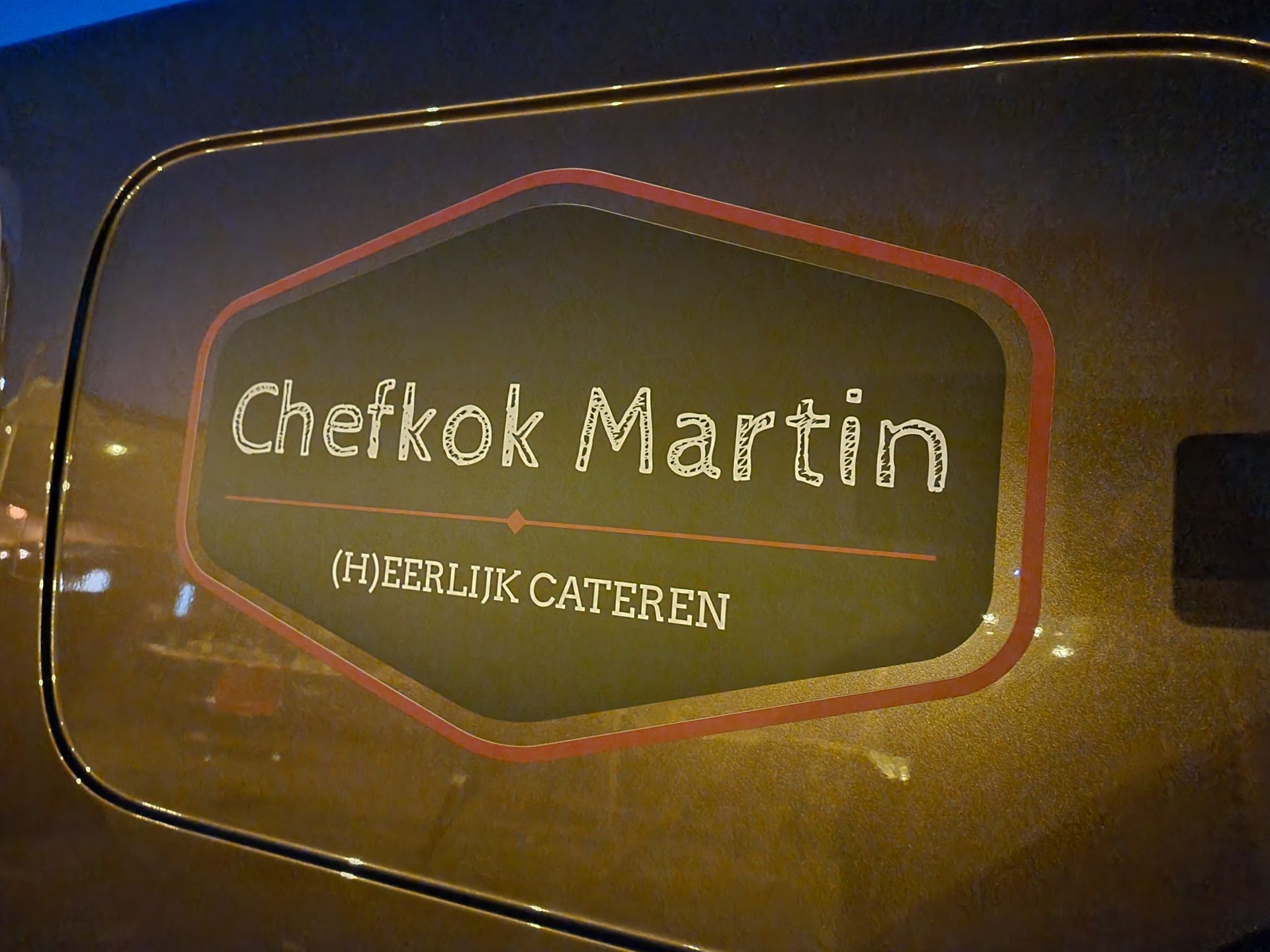 Logo op een bestelwagenraam met de tekst 