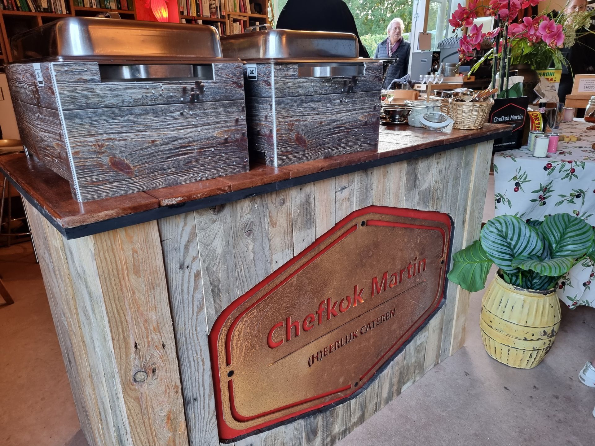 Een houten bar met twee chafing dishes.