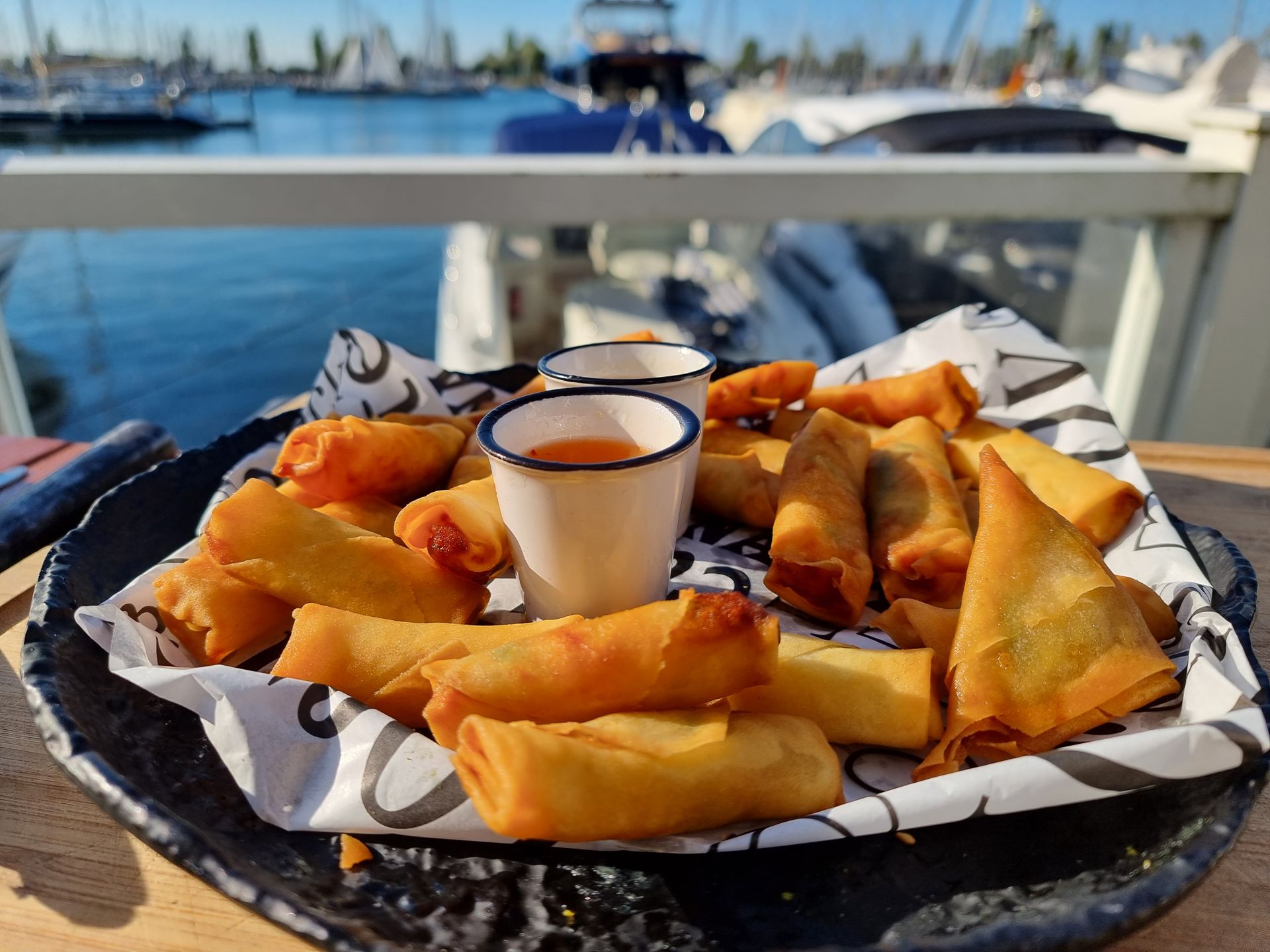 Een bord met gefrituurde hapjes en dipsaus.