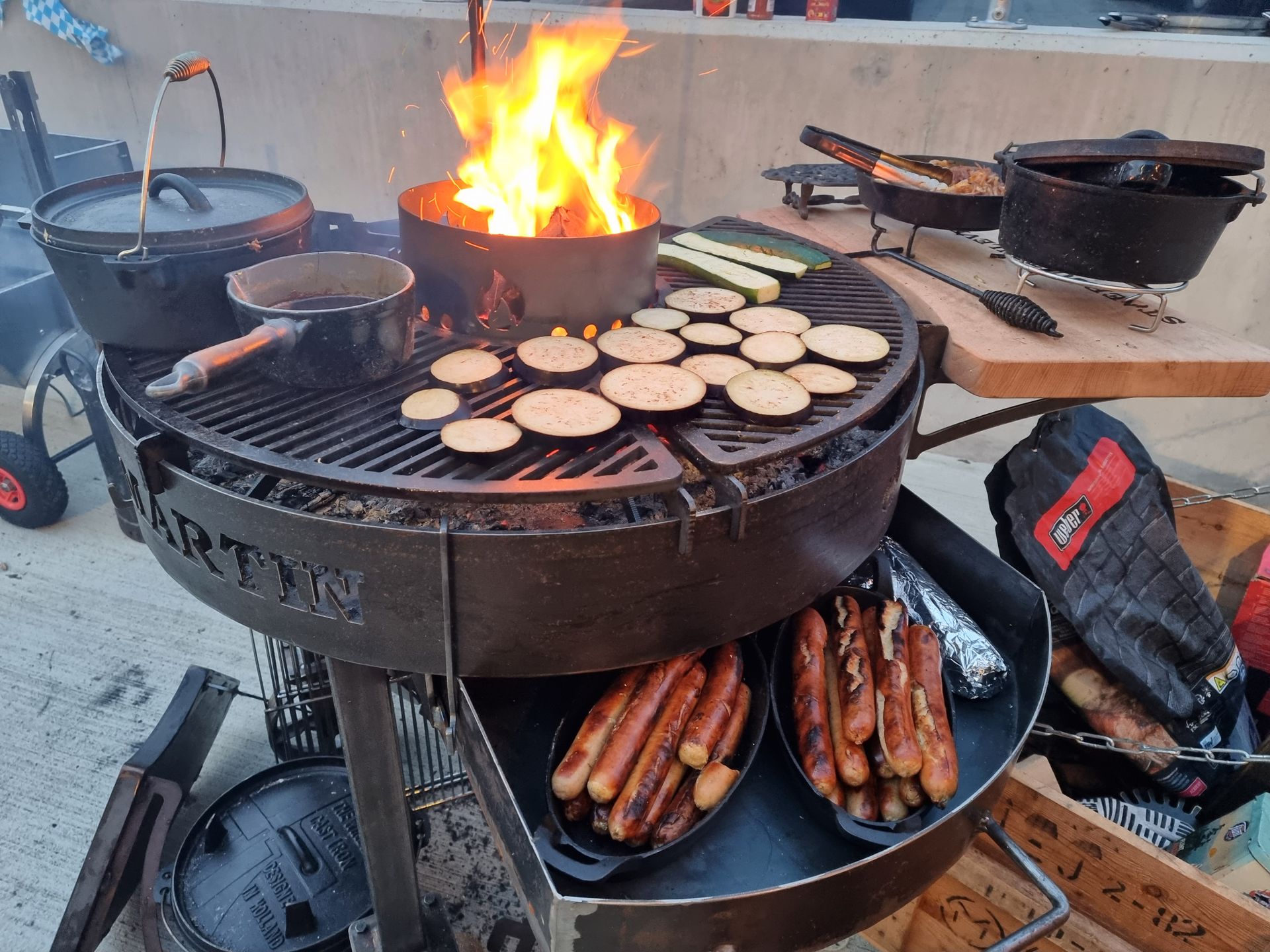 Een barbecue-opstelling met een open vuur, waarop groenten gegrild worden.