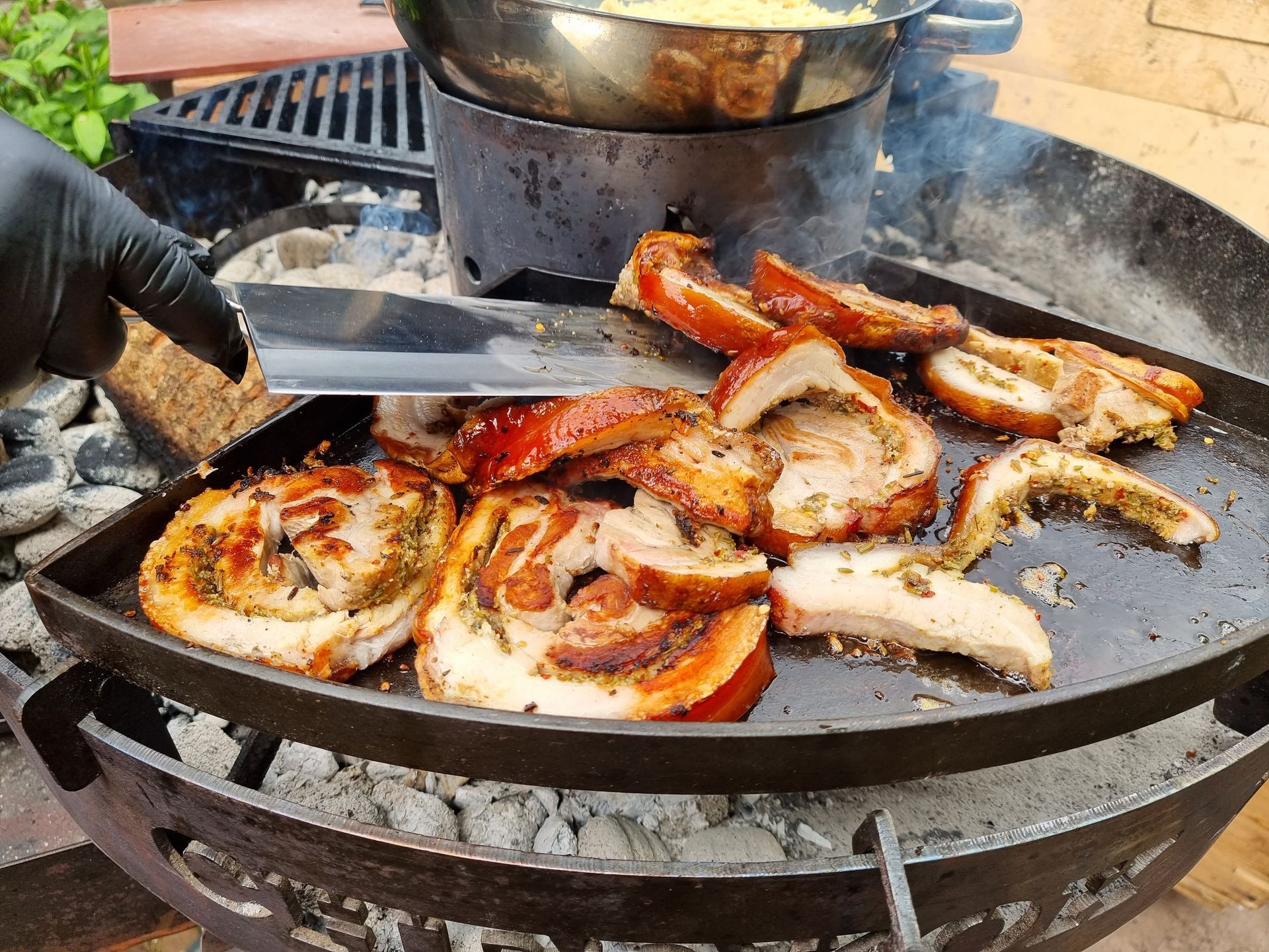 Gegrilde knapperige varkensbuik op een bakplaat van een barbecue. Een rokerige scène van buiten koken.