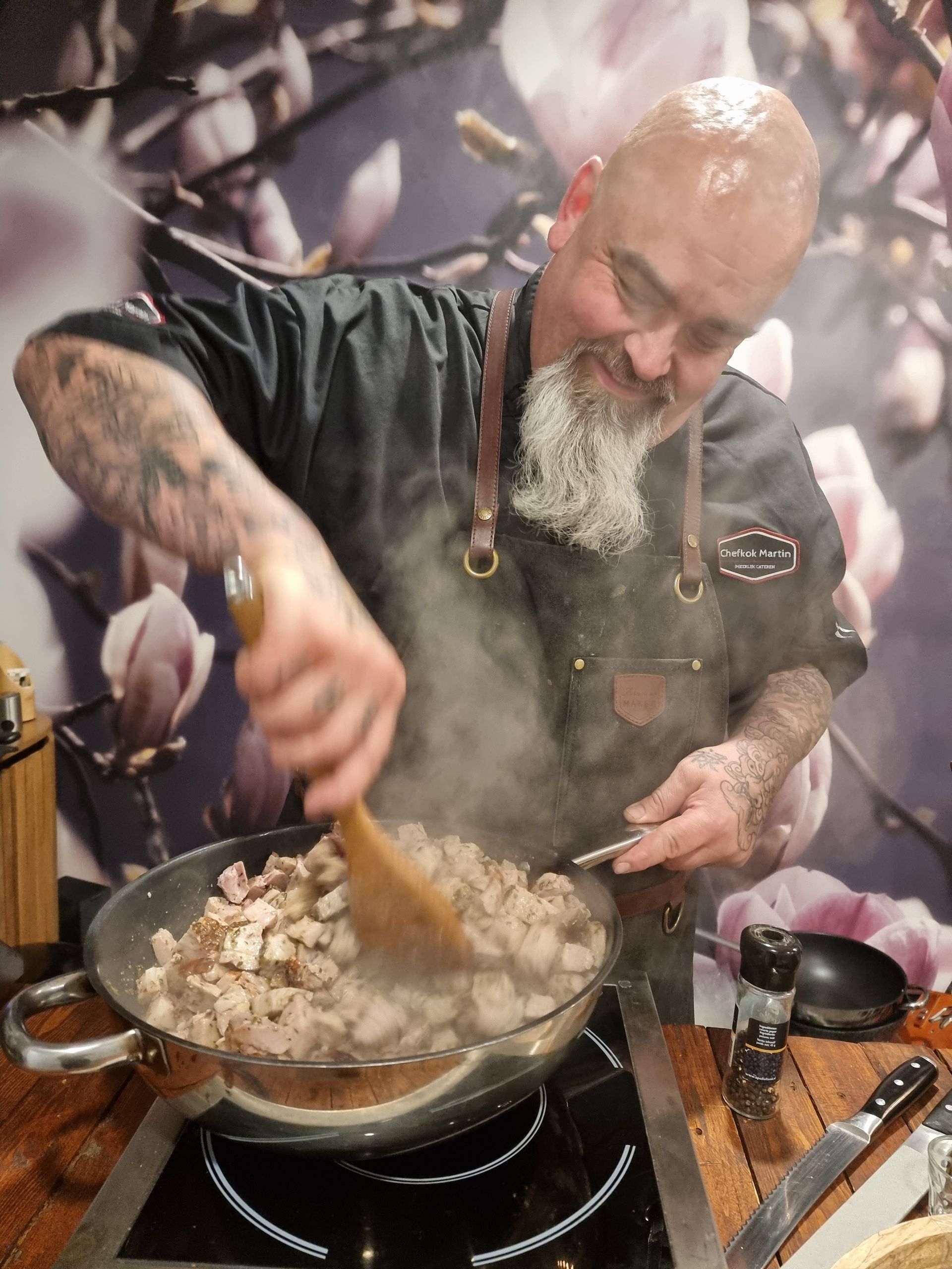 Chefkok Martin roert in een pan. Er stijgt rook op.