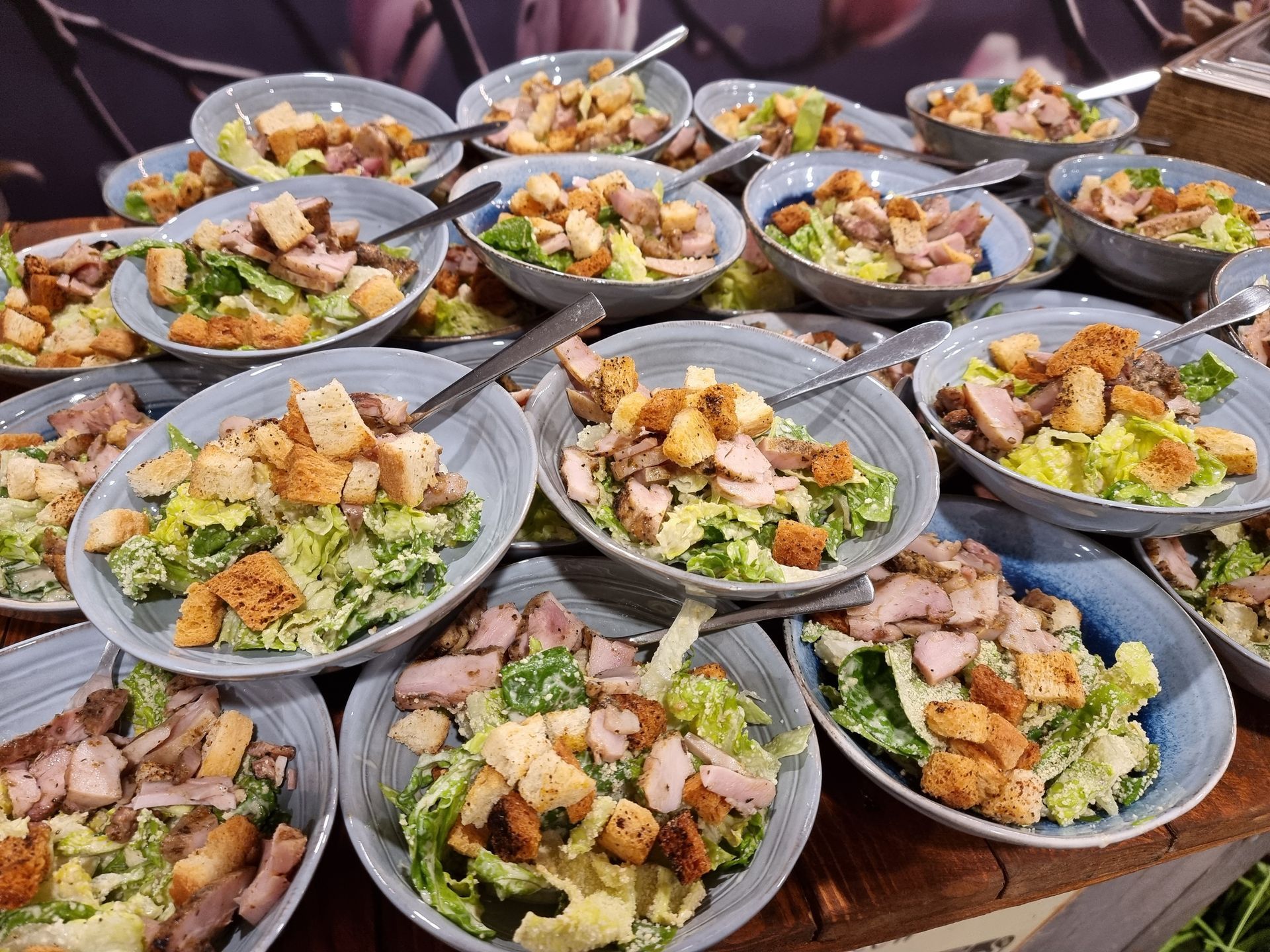 Schalen met Caesar salade, kip en croutons, klaar om te serveren.