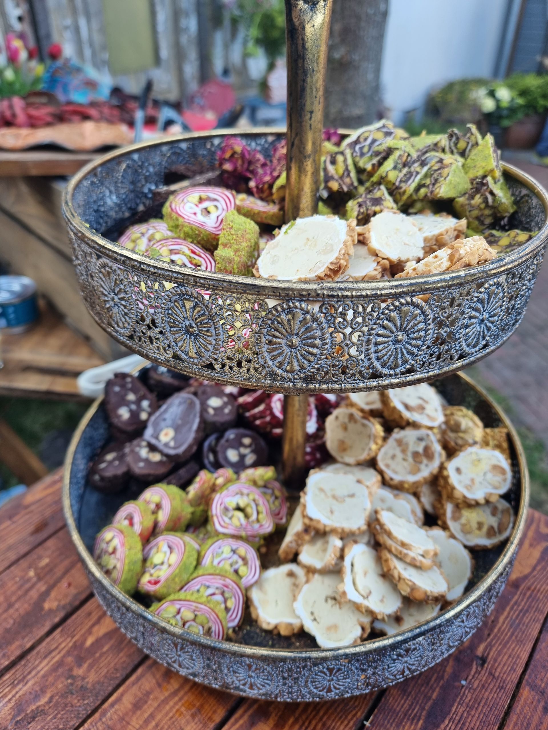 Tweelaags serveerschaal met Turkish delight. Diverse kleuren, gouden frame, houten tafel.