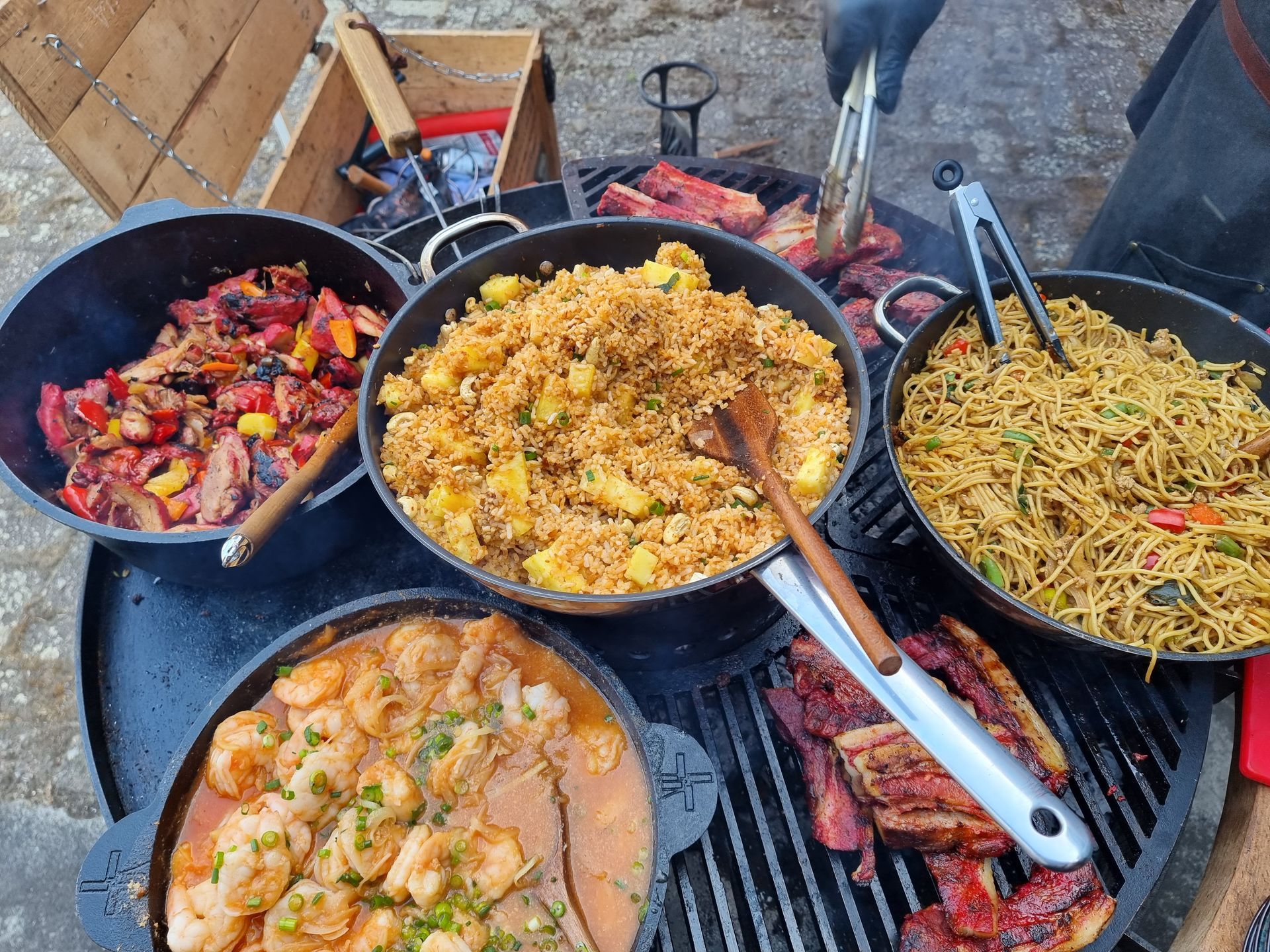 Diverse gerechten op de grill: gebakken rijst, noedels, gegrild vlees en garnalenstoofpot. 