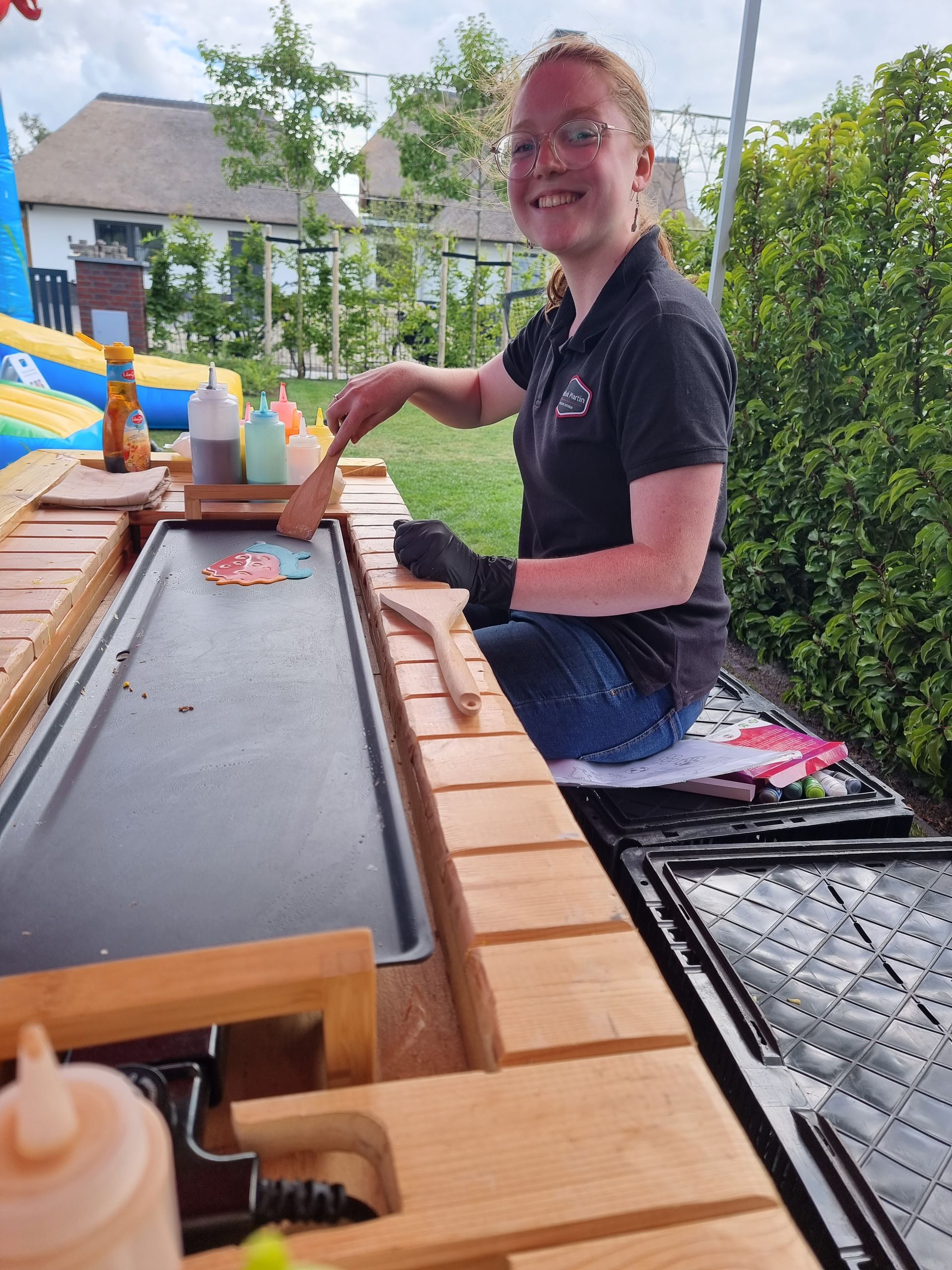 Vera maakt pancake-art op een bruine houten bar.