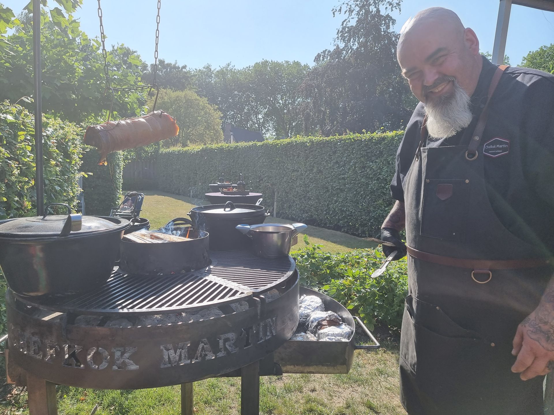 Chefkok Martin bij zijn barbecue met ​​braadpannen. 
