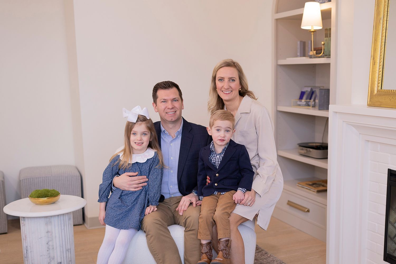 A family is posing for a picture in the waiting room at Carson Williams MD Facial Plastic Surgery office in Leawood KS