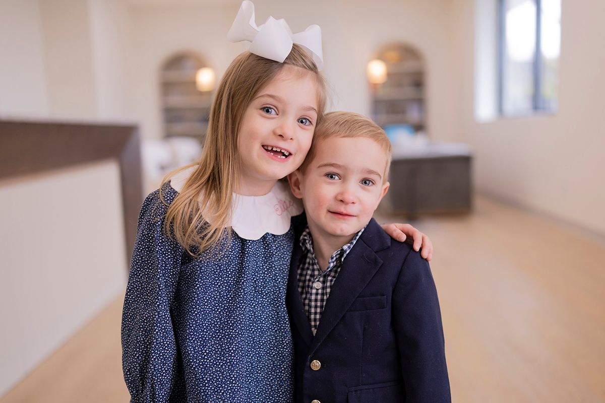 A boy and a girl are posing for a picture together in a room in Leawood KS