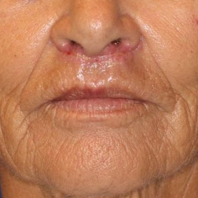 A close up of a woman 's face with a blue background.