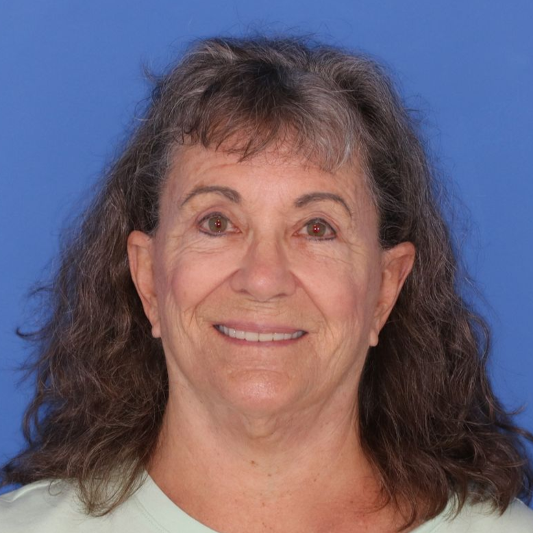 69 year old female posing in front of a blue background 
