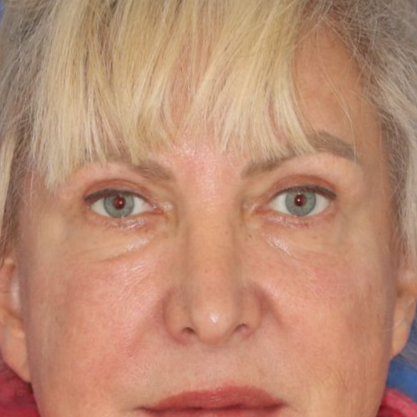 60 year old female posing in front of a blue background