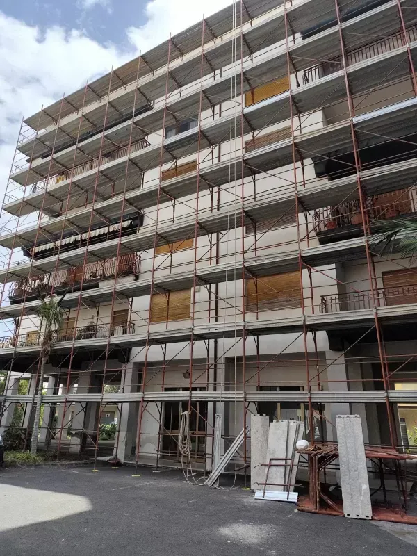 Facciata di un edificio in fase di ristrutturazione con impalcature.