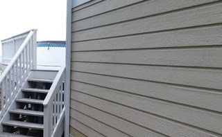 Staircase with white railing next to light-colored siding.