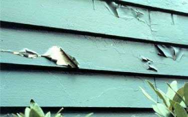 Peeling blue paint on horizontal siding.