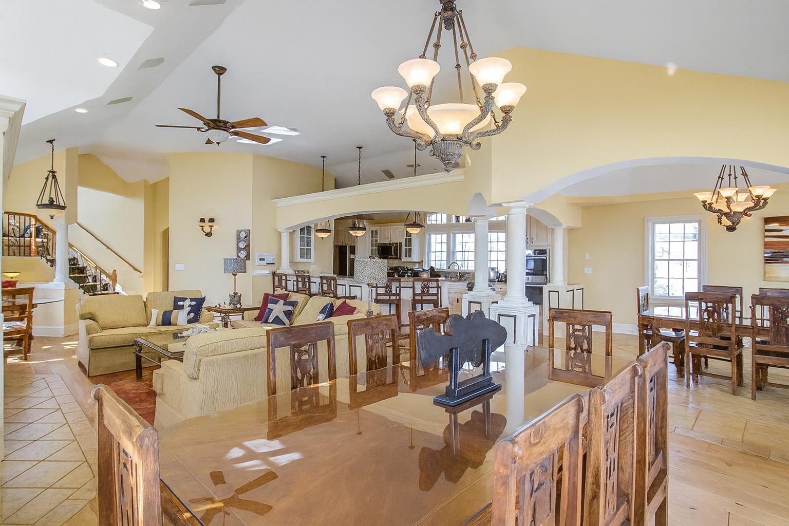 Open-concept living space with dining table, sofa, kitchen, and multiple light fixtures.