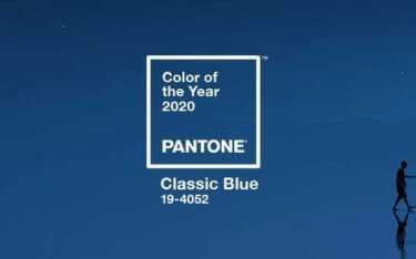 Pantone Color of the Year 2020: Classic Blue. White logo over a blue background. Person silhouetted walks.