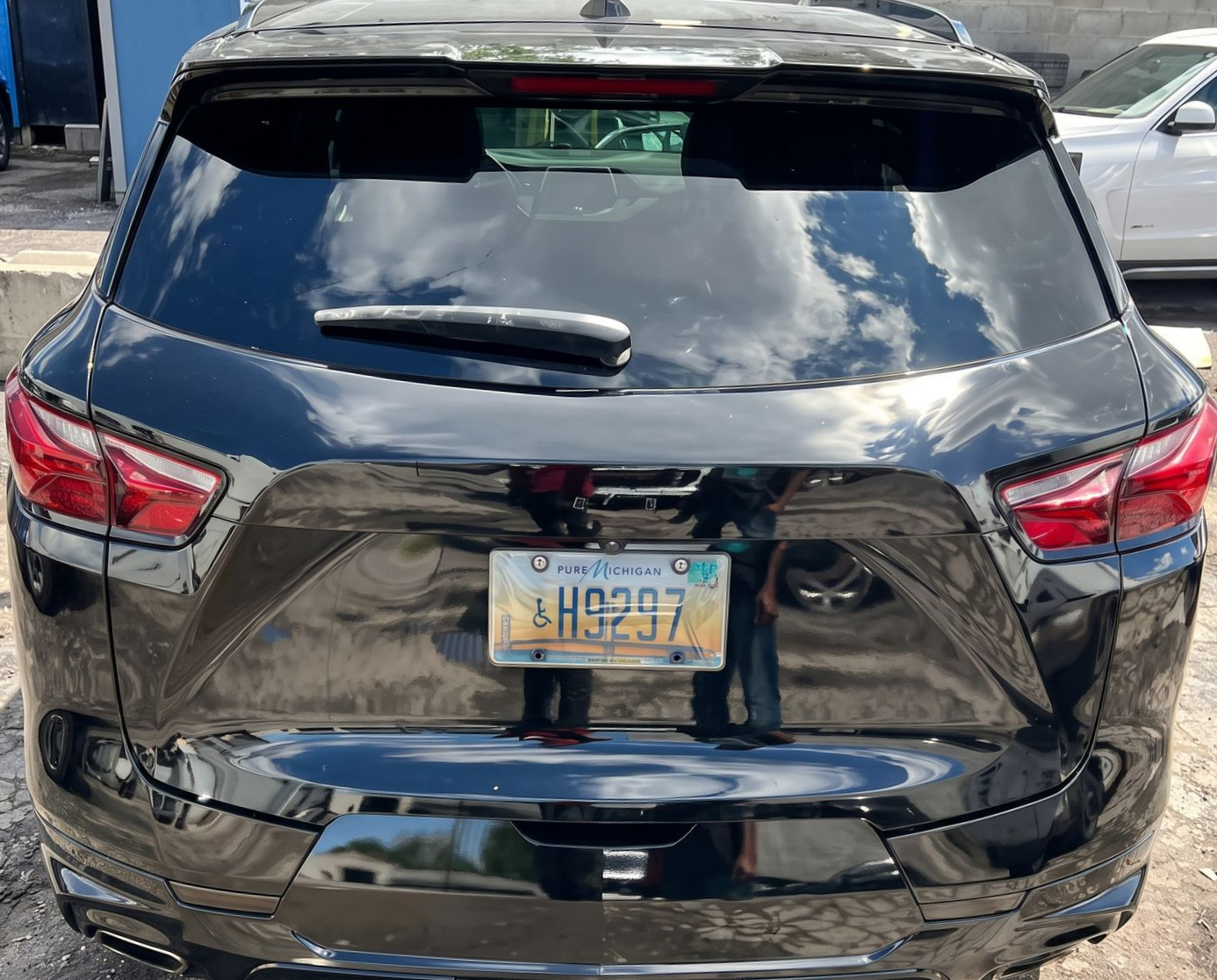 Damaged black SUV rear view with smashed tailgate and bent license plate in a parking lot