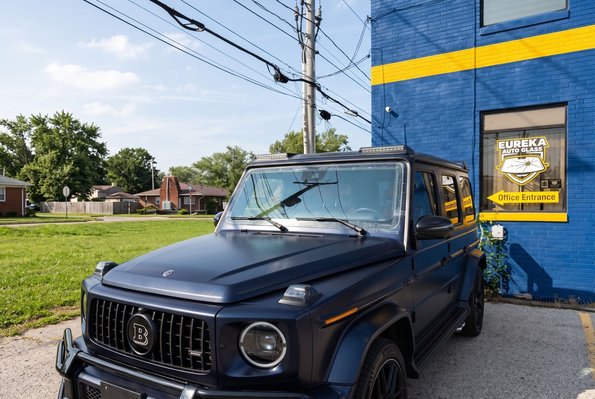 Black SUV parked beside a blue brick building with a yellow sign on the wall