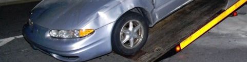 Let's explain local towing costs and rates! A silver car is being towed by a tow truck.