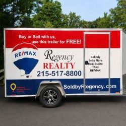 RE/MAX Regency Realty trailer with red and white branding, phone number, and soldbyregency.com website