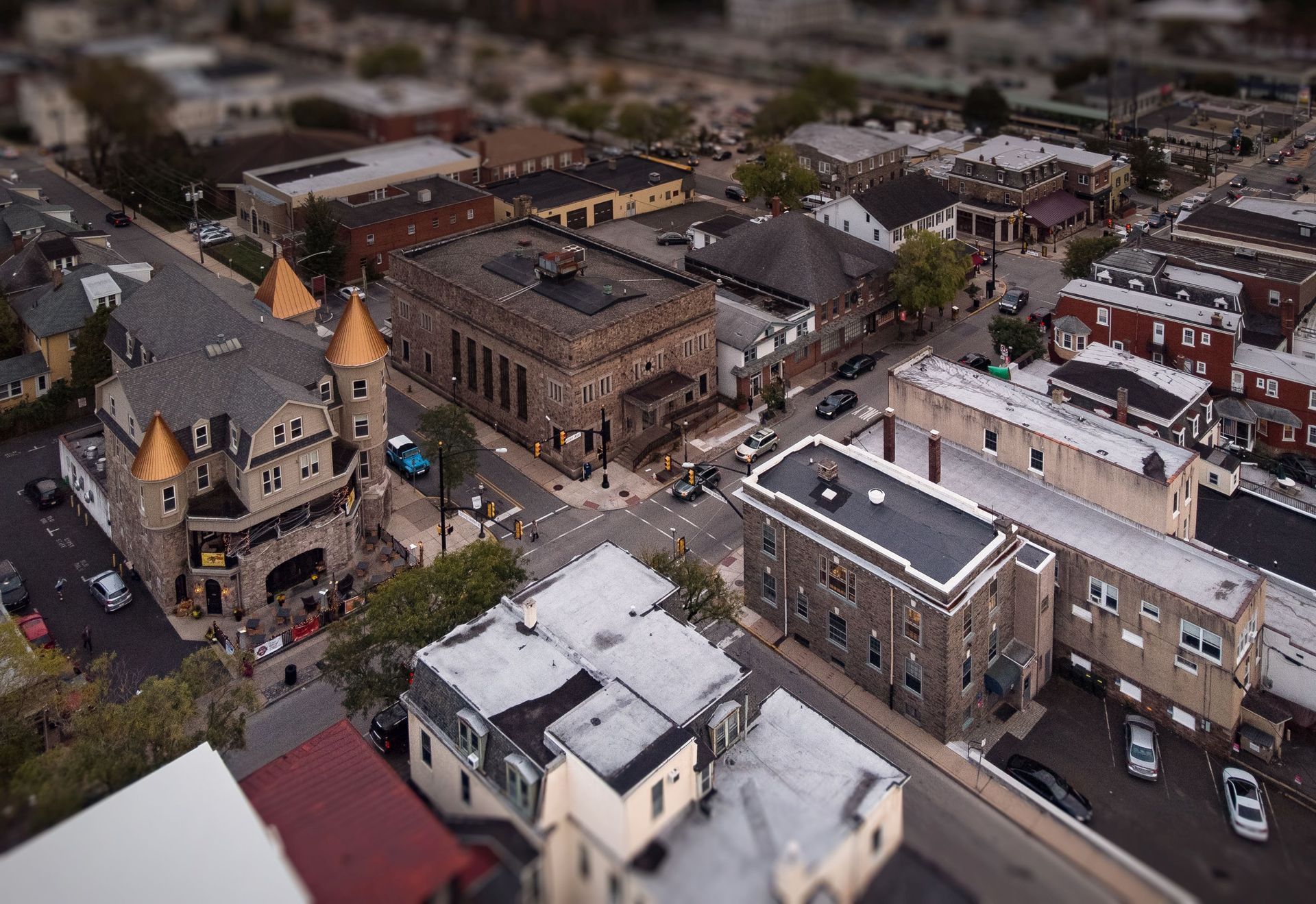 Aerial view of a town center with historic buildings, streets, and parked cars.