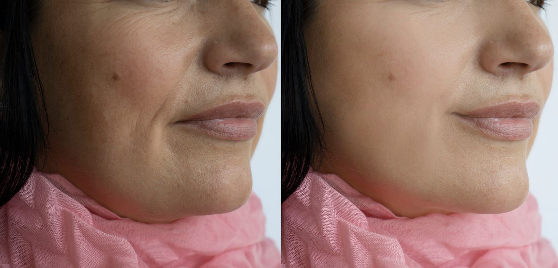 A woman is touching her face with her hands and smiling.