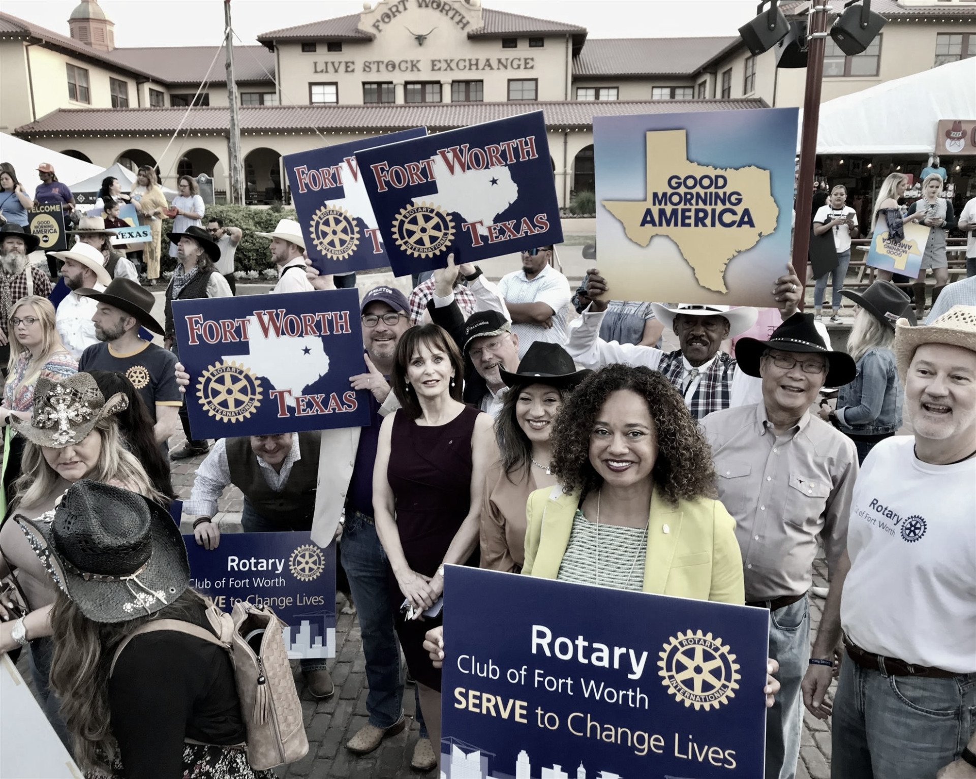 Group of people holding signs in front of a building;