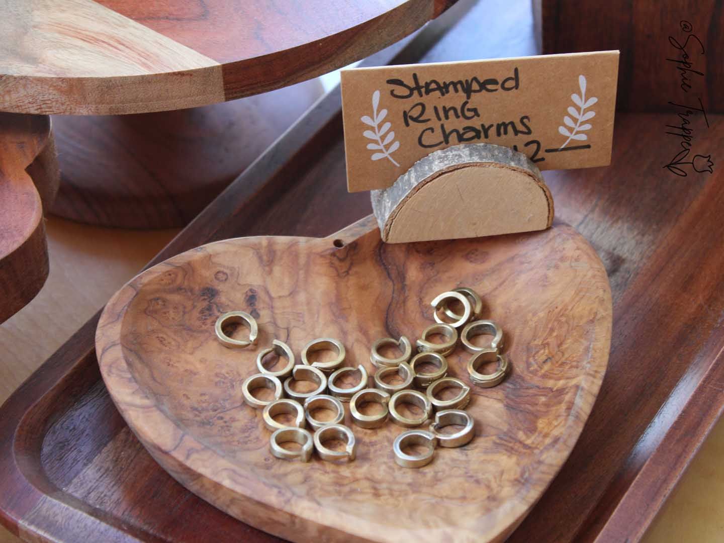 Wooden bowl of ring-shaped snacks with a small sign reading “served ring charms”