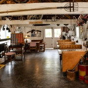 Rustic café interior with wooden tables, benches, white beams, and red fire extinguishers by the wall