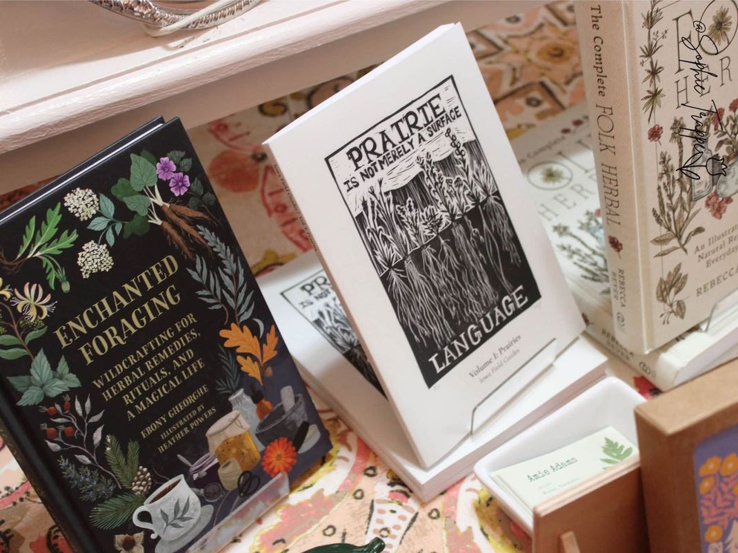 Decorative display of colorful tarot and oracle card decks on a table, including “Enchanted Tarot” and “Practical Magic.”