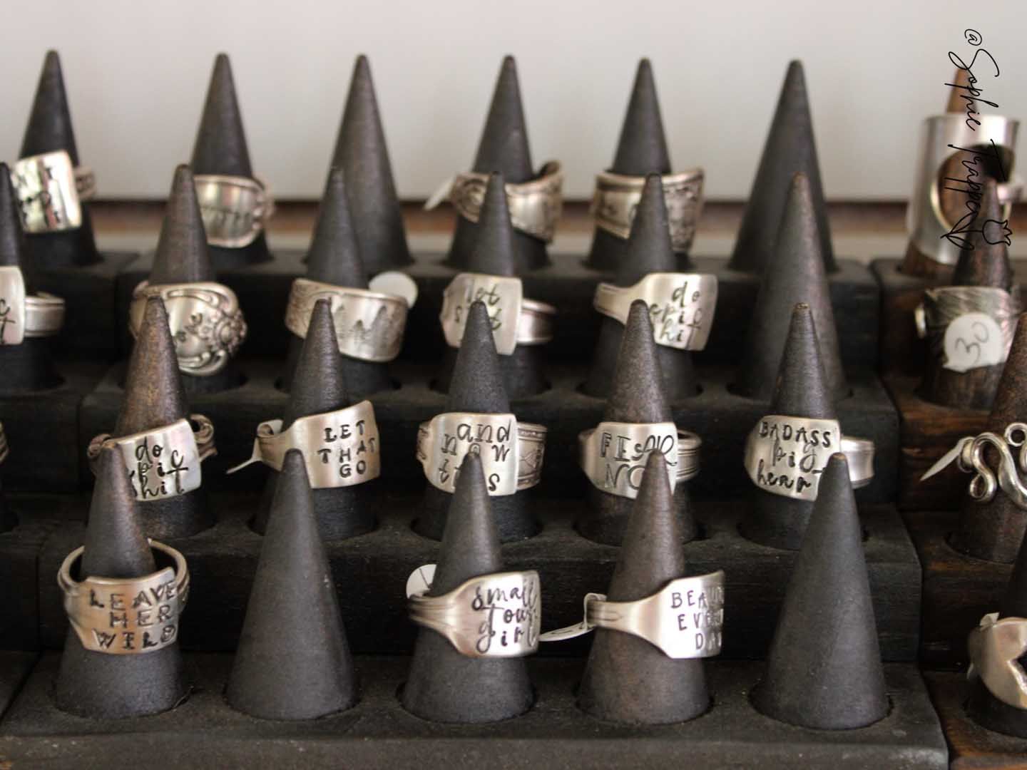 Silver rings displayed on black cone stands in a jewelry showcase