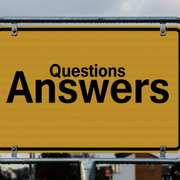 Yellow sign with bold black text reading “Questions Answers” against a gray background