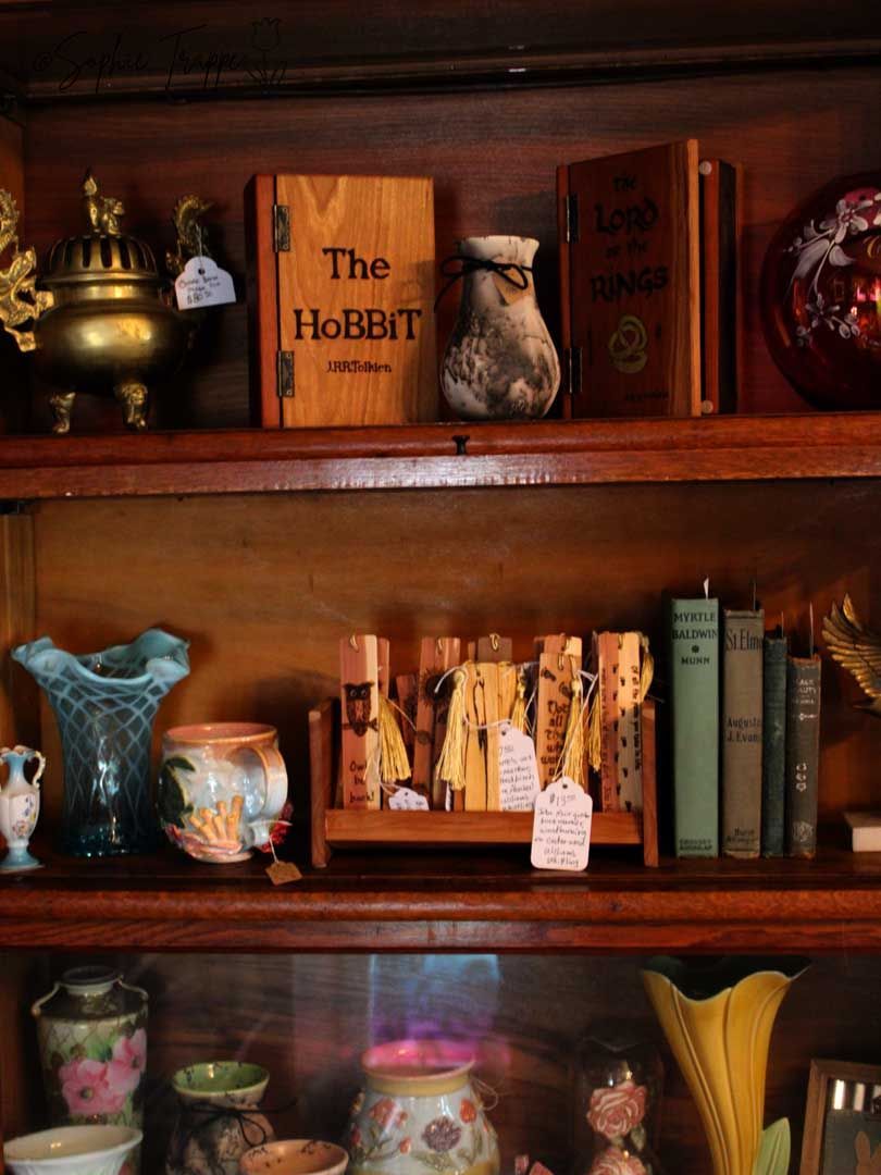 Wooden shelves filled with books, vases, and decor, including a copy of The Hobbit.