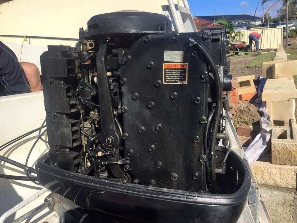 A Black Outboard Motor Is Sitting on The Side of A Boat — Don's Marine Repairs in Brisbane Waters, NSW