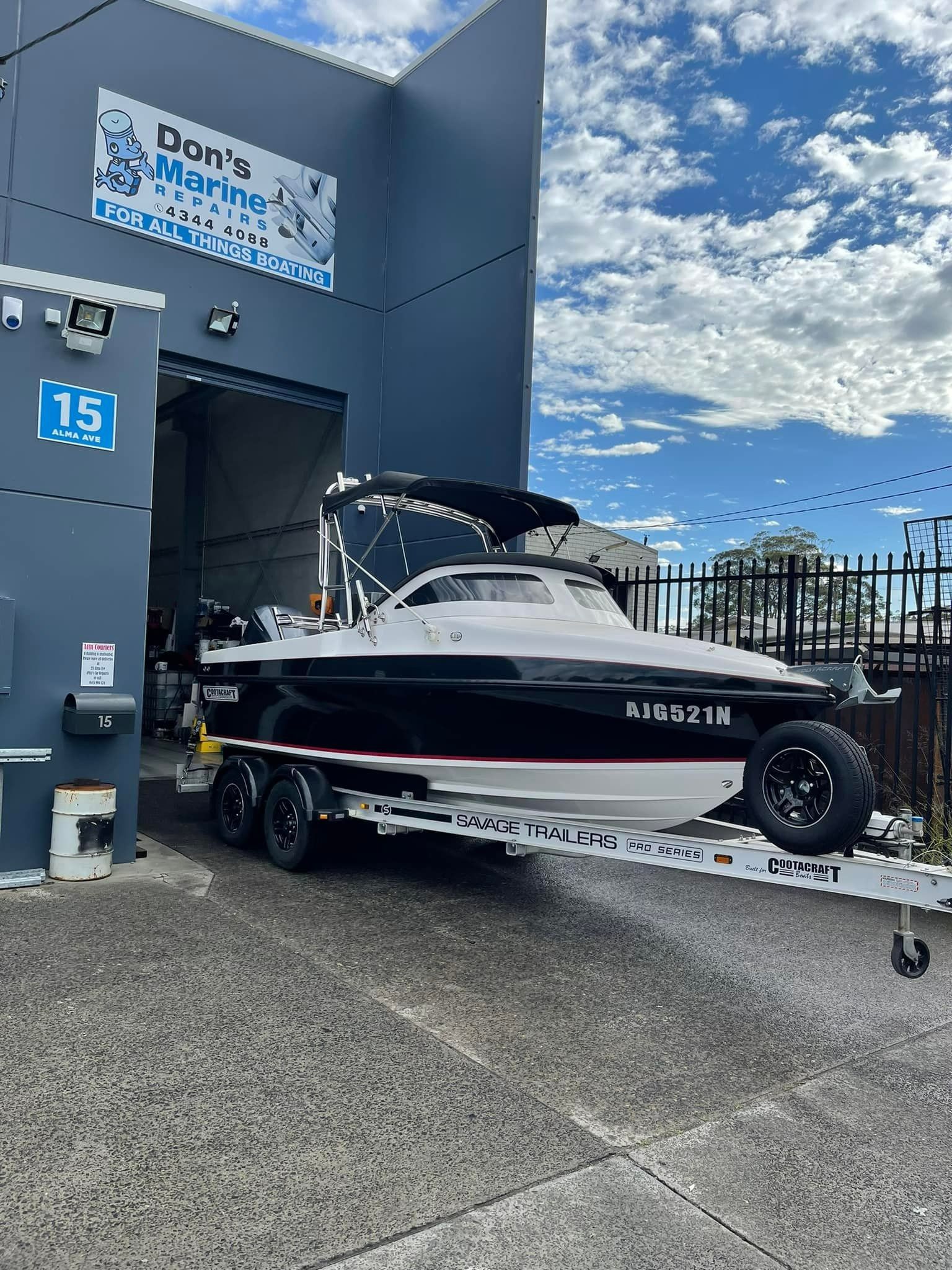 A Boat Is Sitting on A Trailer in Front of A Building — Don's Marine Repairs in Woy Woy, NSW