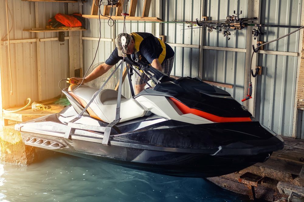 A Man Is Working on A Jet Ski in A Garage — Don's Marine Repairs in Woy Woy, NSW