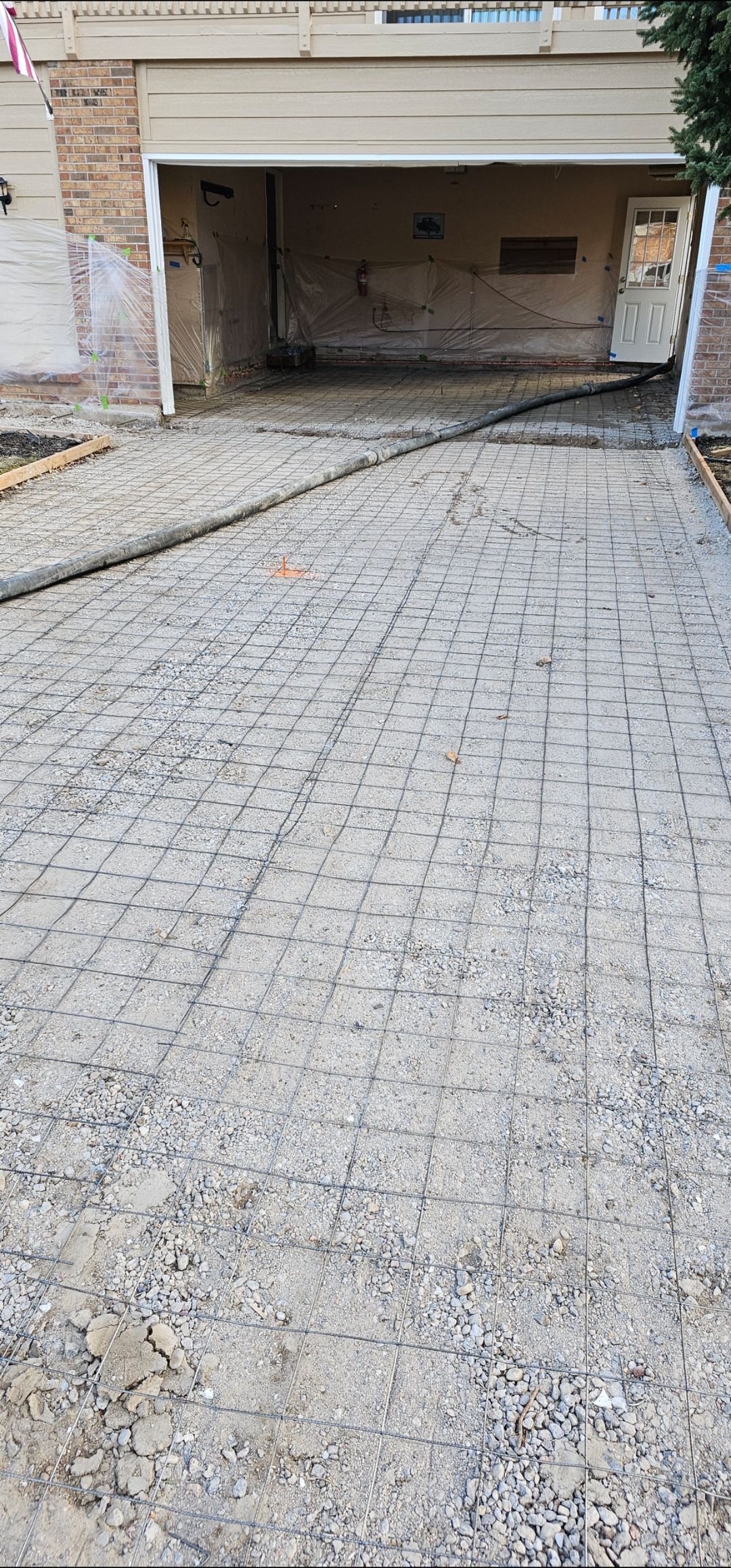 Stone driveway leading to an open garage with a raised white barrier across the entrance
